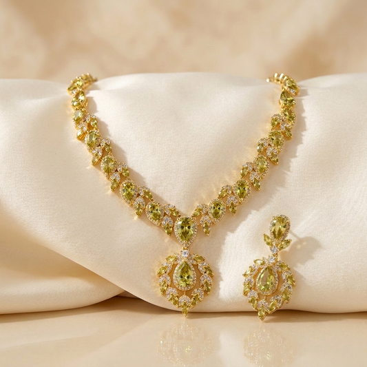 Wide bib necklace massed with olive-yellow cubic zirconia in gold-plated brass, with matching drop earrings