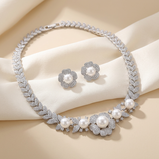 Bridal necklace and earring set with pavé cubic zirconia blossoms and imitation pearls in rhodium-plated brass