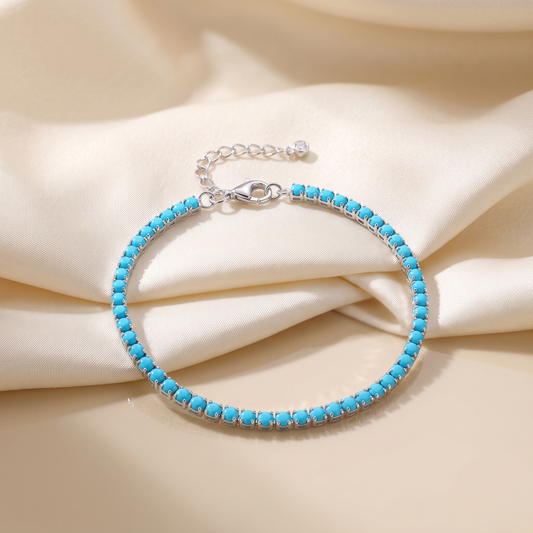 Round natural turquoise stones claw-set along a rhodium-plated sterling silver tennis bracelet
