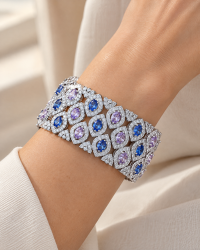 Wrist wearing the Wide Oval Leaf Statement Cuff, blue and lavender cubic zirconia in rhodium-plated settings