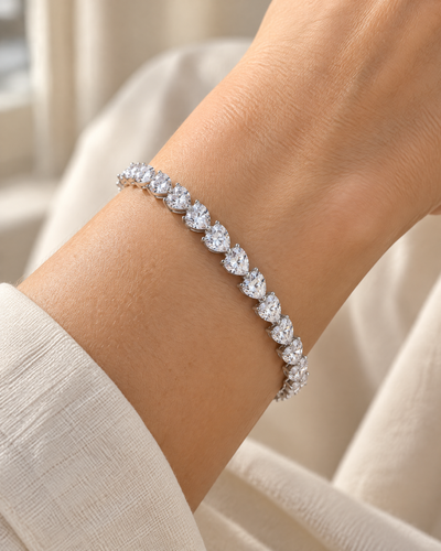 Wrist wearing the Crystal Heartline Tennis Bracelet, heart-cut cubic zirconia in rhodium-plated sterling silver